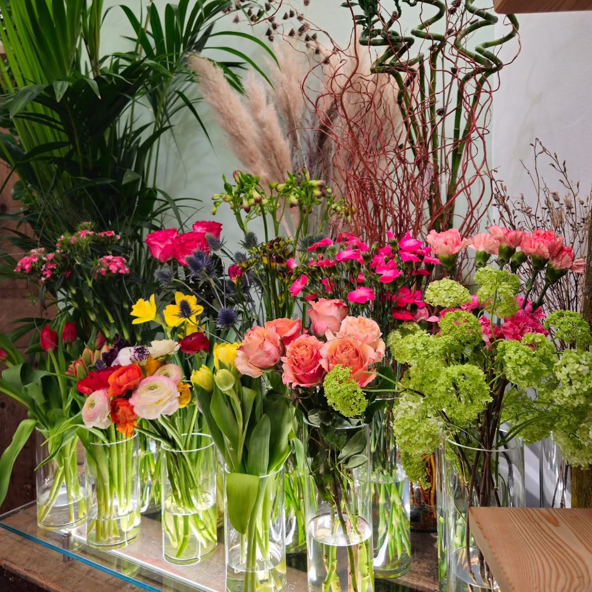 Ricca scelta di fiori freschi recisi in vasi di vetro nel negozio di fiori Viridis