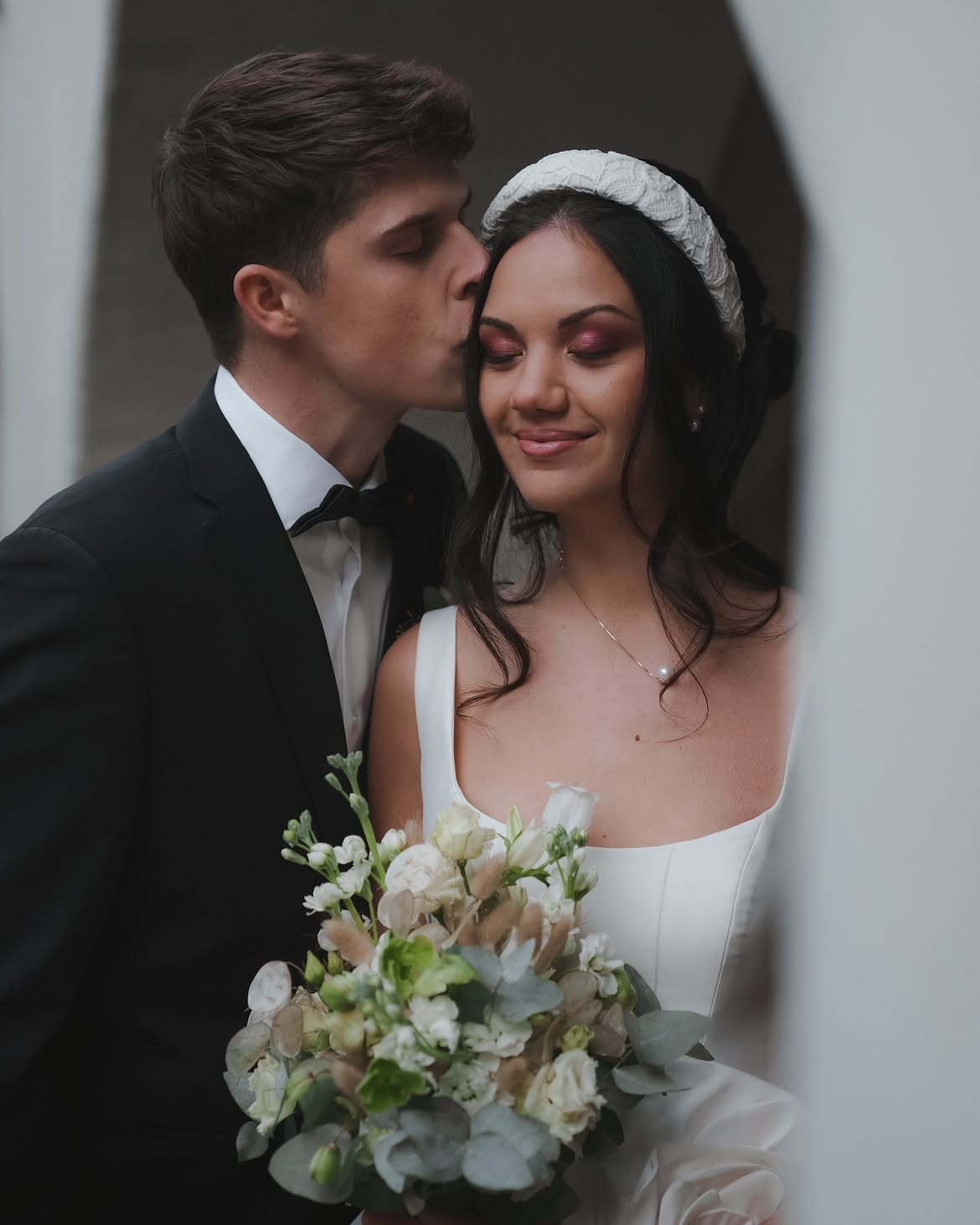 Coppia di sposi con bouquet di fiori bianchi ed eucalipto