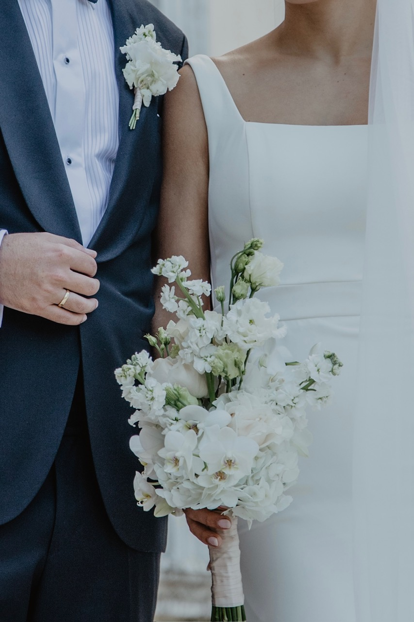 Coppia di sposi con bouquet bianco di orchidee e violacciocche